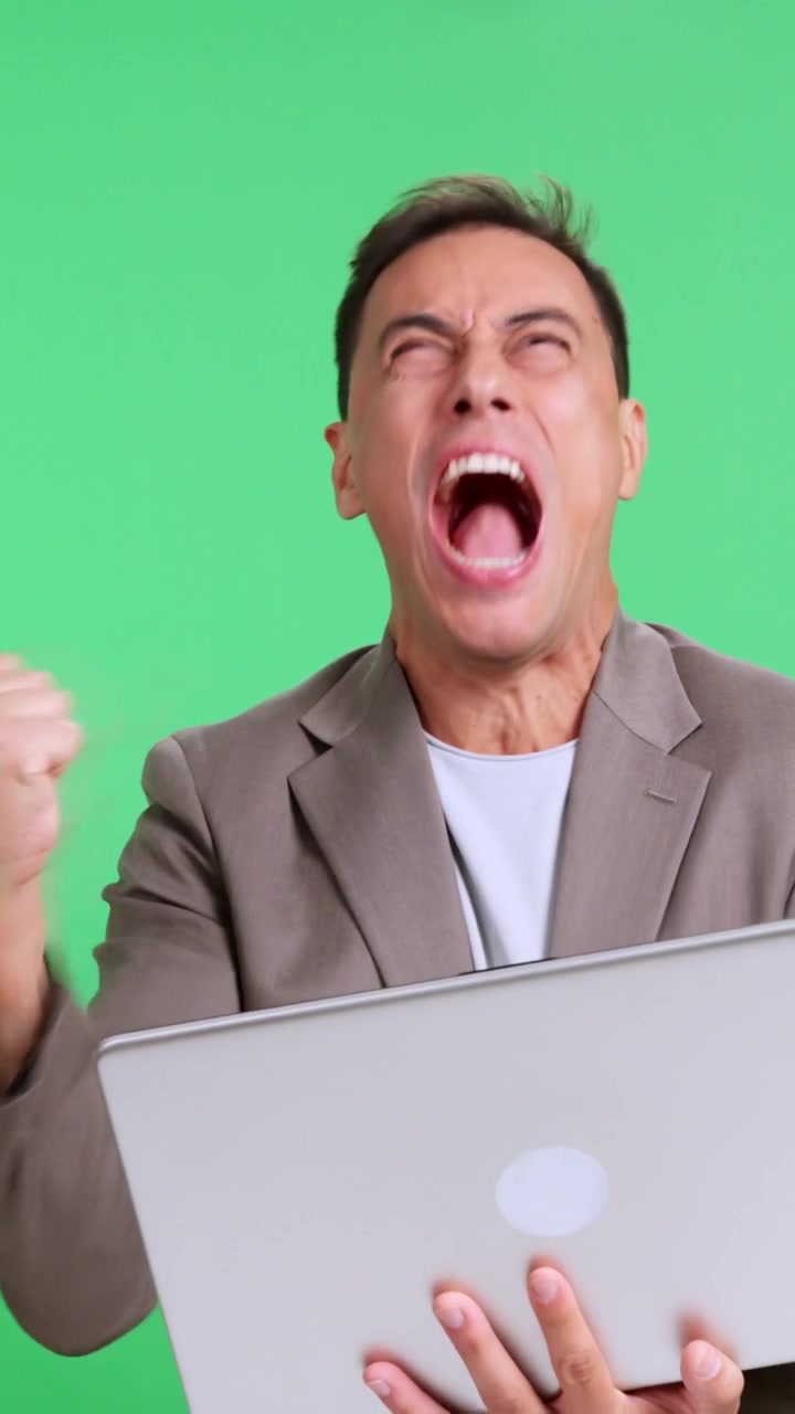 Uomo d'affari di successo che celebra una vittoria usando un laptop