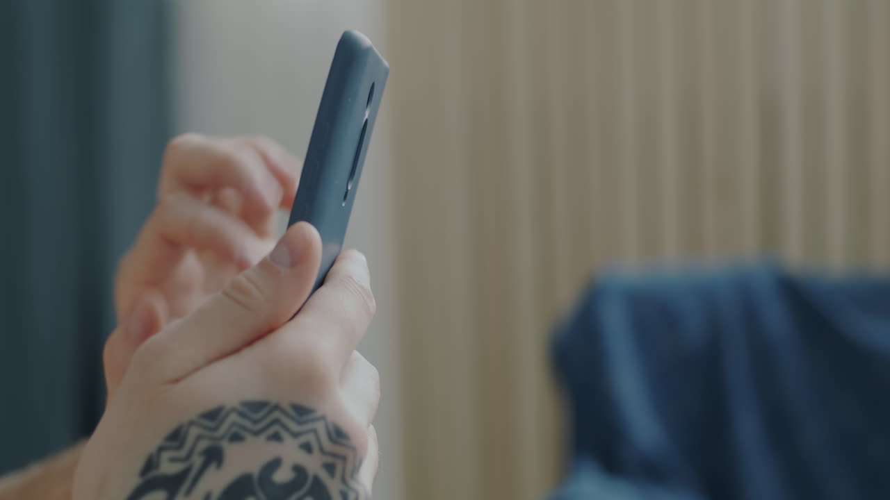 Man using a smartphone and profile view of a bearded man