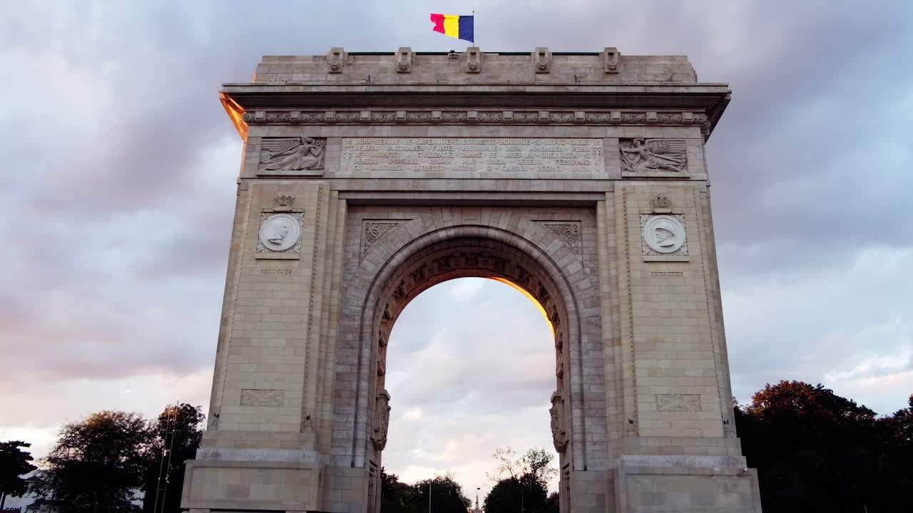 Street view of The Triumphal Arch in Bucharest, Romania at sunset