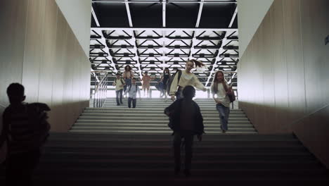 students running down stairway with backpacks. schoolchildren leaving school.