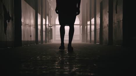 a bald man walks on the empty hospital corridor at night