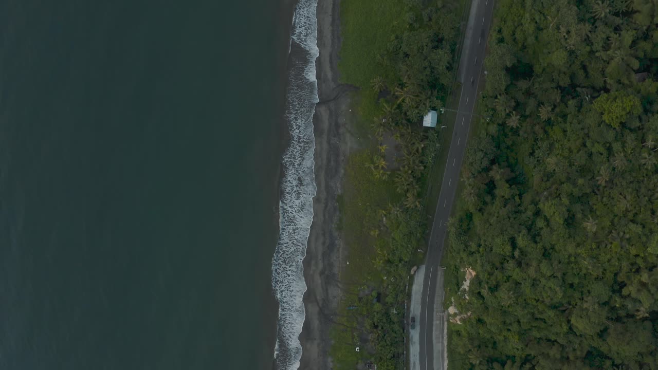 여름 동안 필리핀의 도로를 따라 단풍 산 풍경 옆 해변의 거품 파도