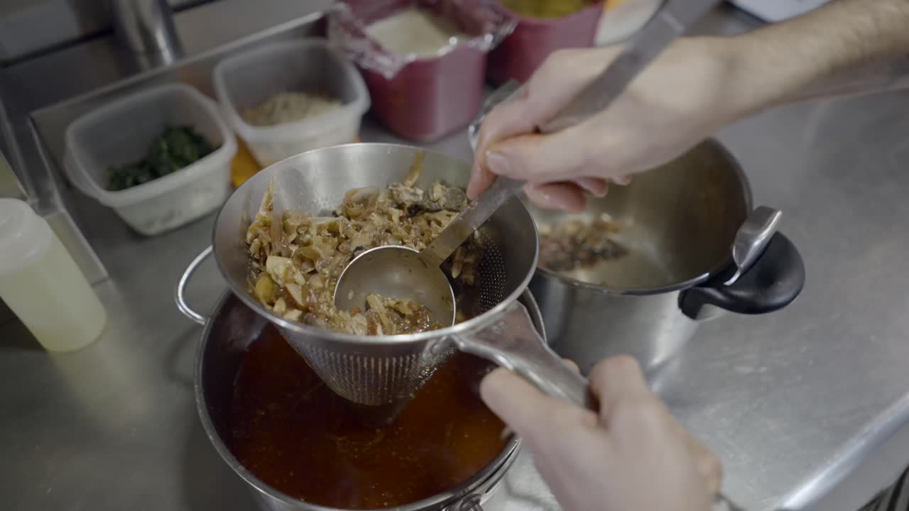 Straining a soup or stew in a kitchen