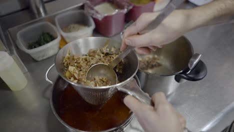 straining a soup or stew in a kitchen