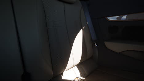 cerca de los asientos traseros de un coche con cuero perforado y interior bronceado
