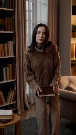 woman holding a book in a living room