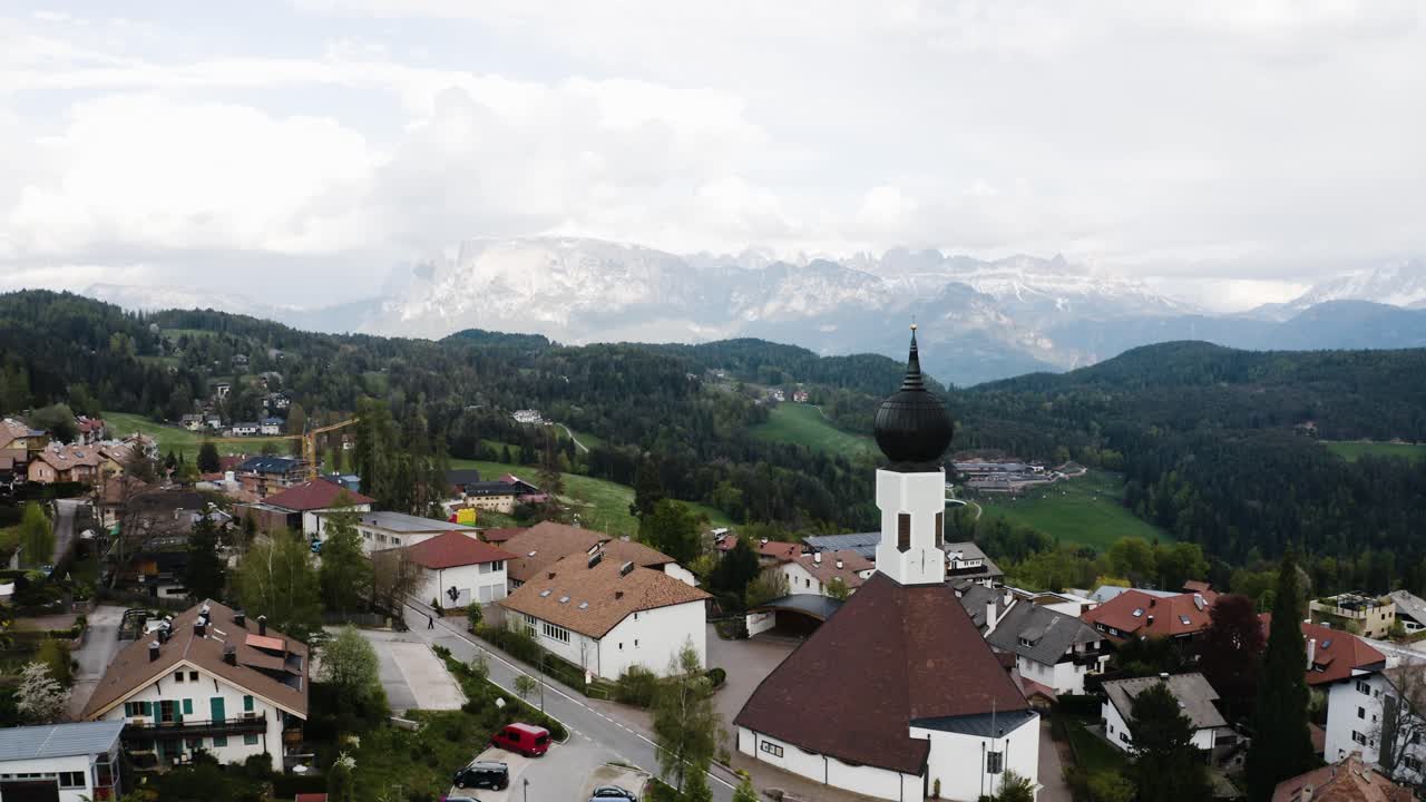 Aerial view flying over the town of Oberbozen in Italy's countryside