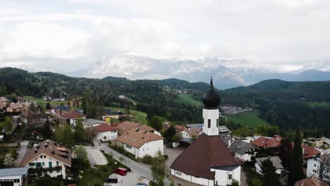 Aerial-view-flying-over-the-town-of-Oberbozen-in-Italy's-countryside