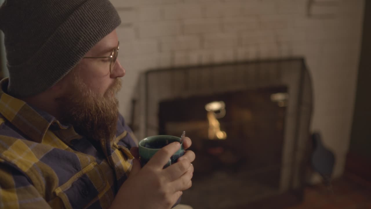 A close up of a man warming up hot tea. Stirring tea and sipping it. Shot in 60 frames for slow motion