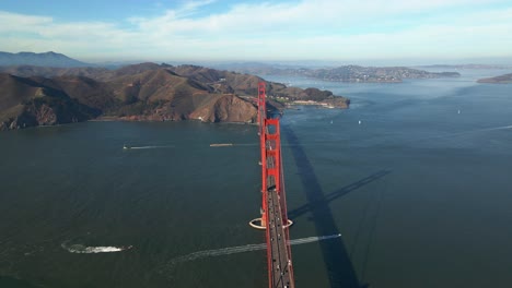 aerial view overlooking car and boat traffic at the golden gate bridge, in sunny california - circling, drone shot