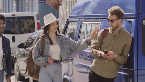 intrepid young boy greets two girls next to his van before a road trip