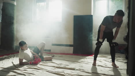 hombres cansados tomando un descanso después de realizar ejercicios intensos en el club de lucha. cansancio por el esfuerzo físico. fatiga y excedente de energía después de un entrenamiento corporal intensivo
