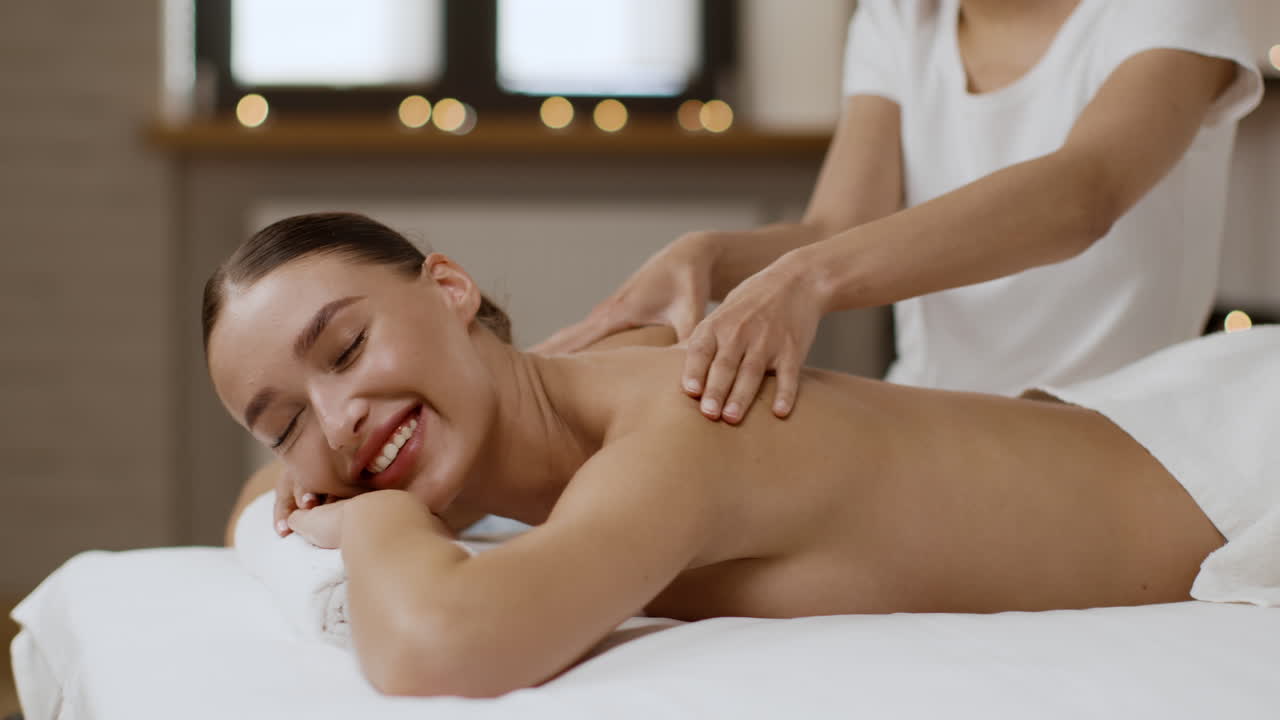 una mujer recibiendo un masaje de espalda en un spa.