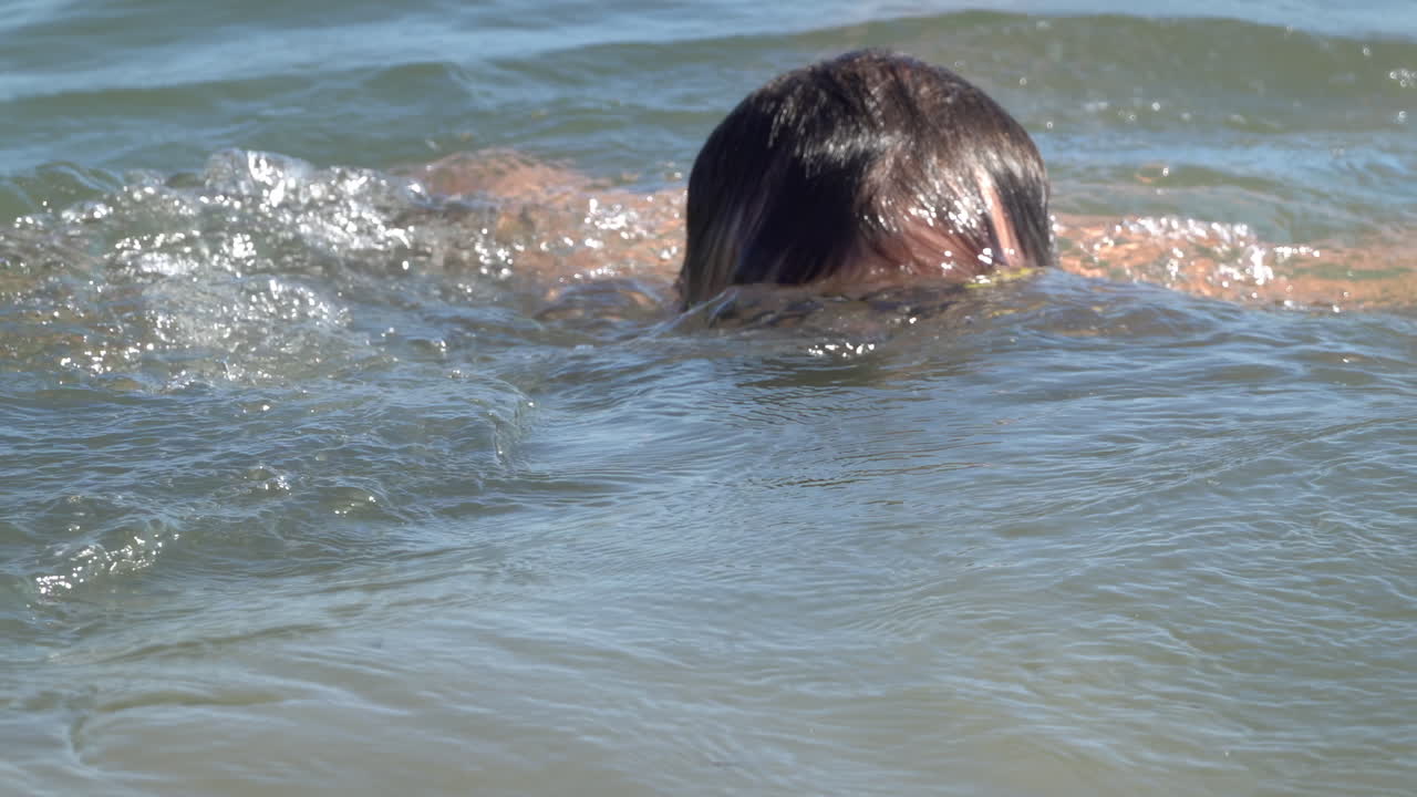 Man wearing swimming goggles diving in the sea