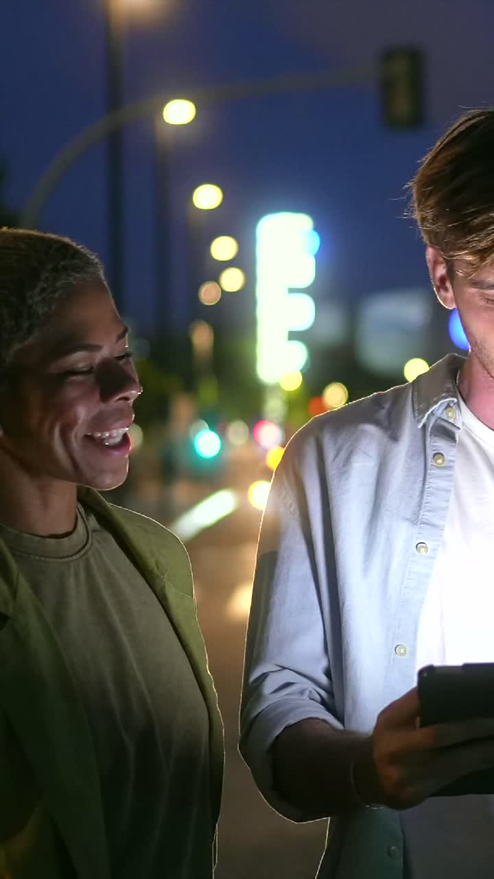 People using a tablet at night in the city