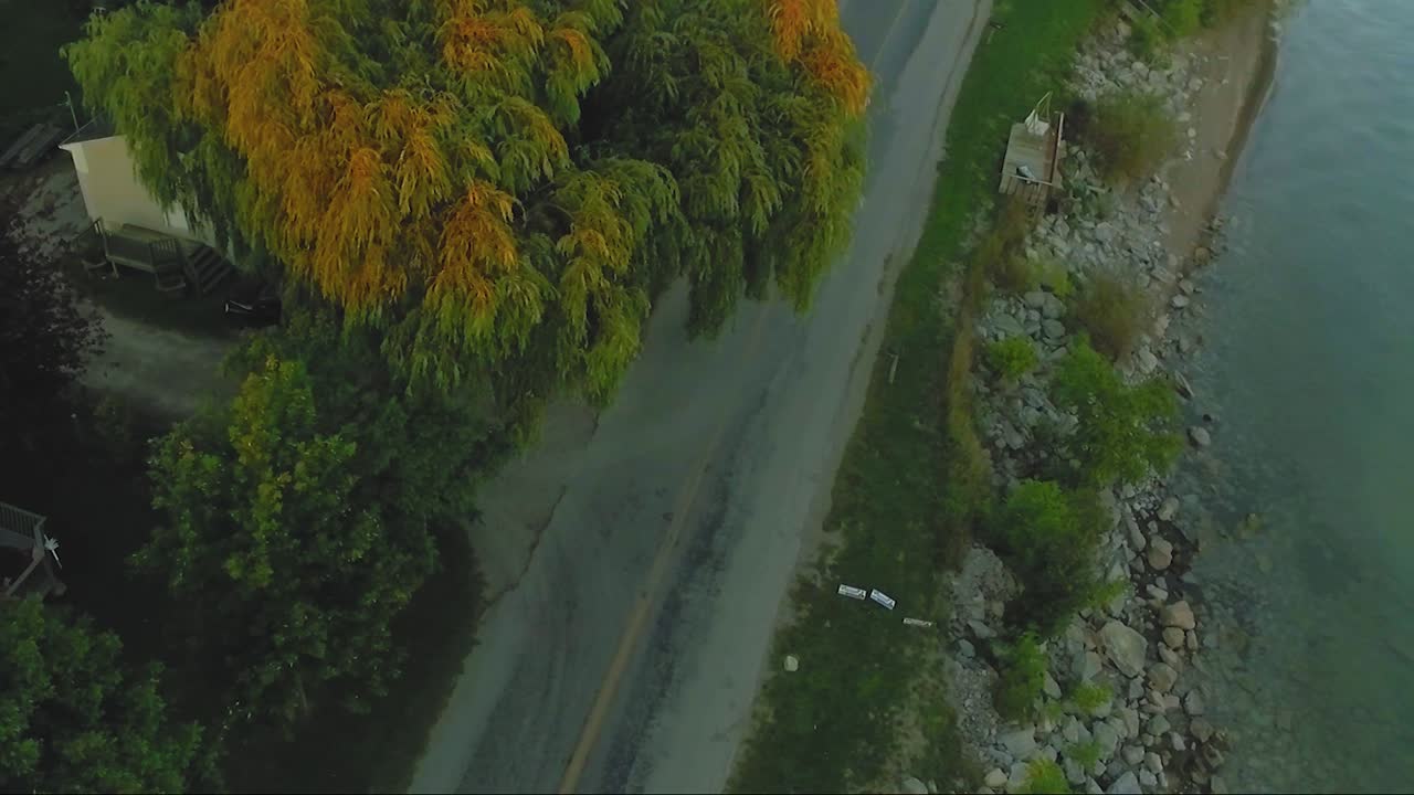3 motociclisti passano sotto un salice al tramonto a Selkirk, Ontario, Canada