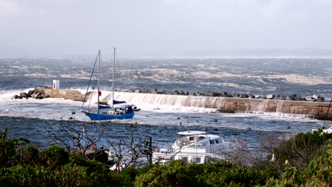 Tempestuous ocean waves in coastal storm crash over dolosse protecting pier