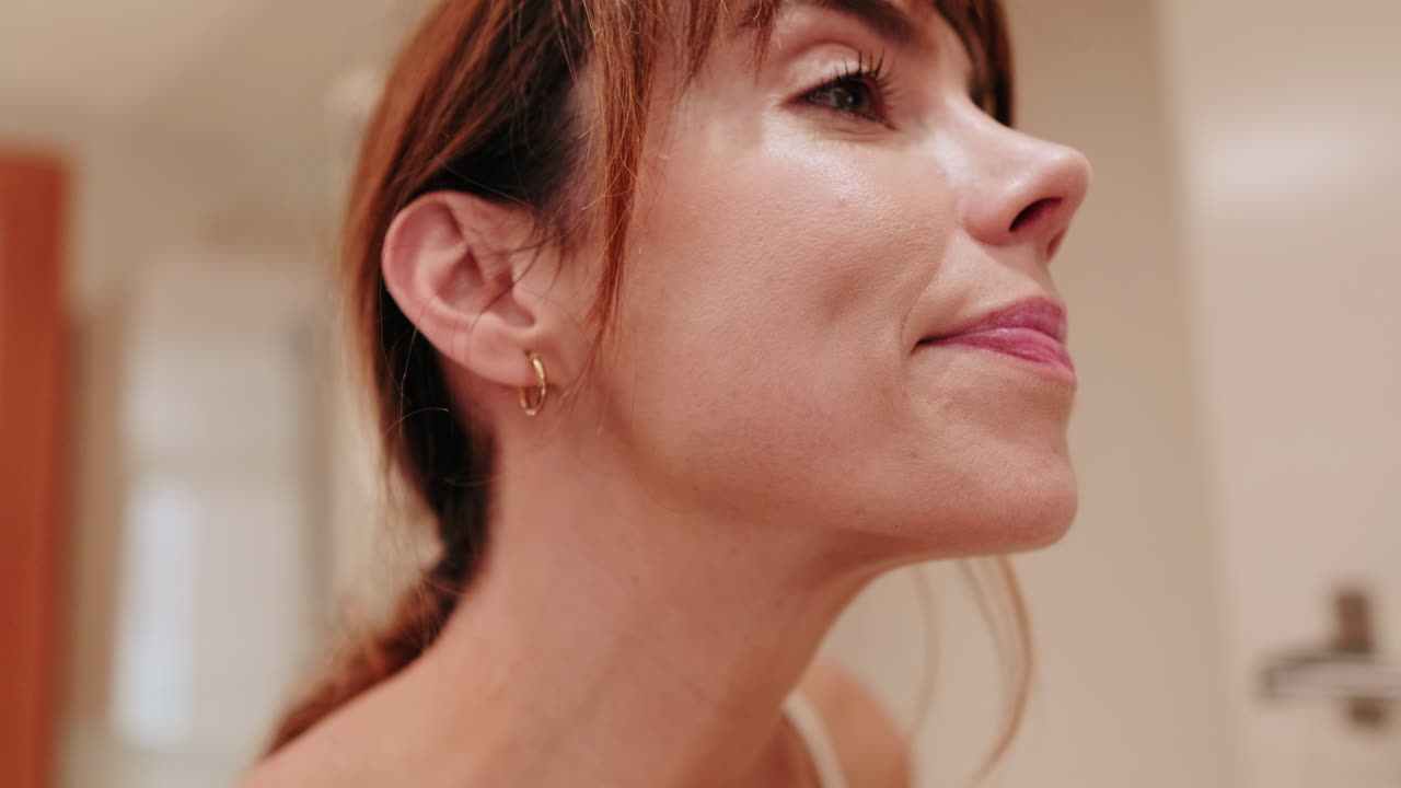 Close-up of Young Woman Applying Lipstick