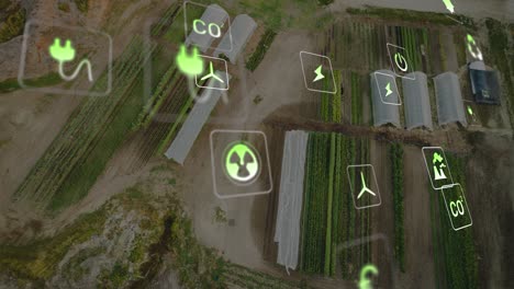 animation of eco icons and data processing over greenhouses and landscape