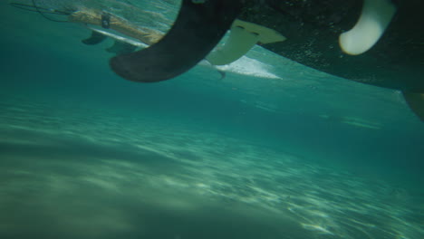 surfista sob ondas cristalinas na baía de byron, na austrália, filmado debaixo d'água.