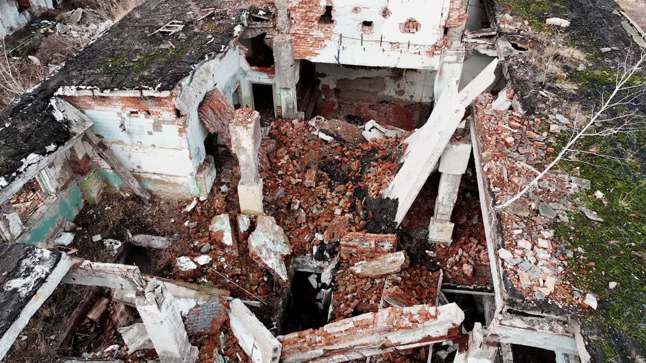 Destroyed architecture after the massive explosion. Enormous hole in the building roof filled with rubbles and debris. Aerial view.