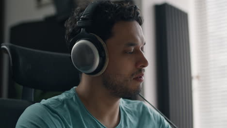 music producer listens attentively with headphones during studio audio playback session