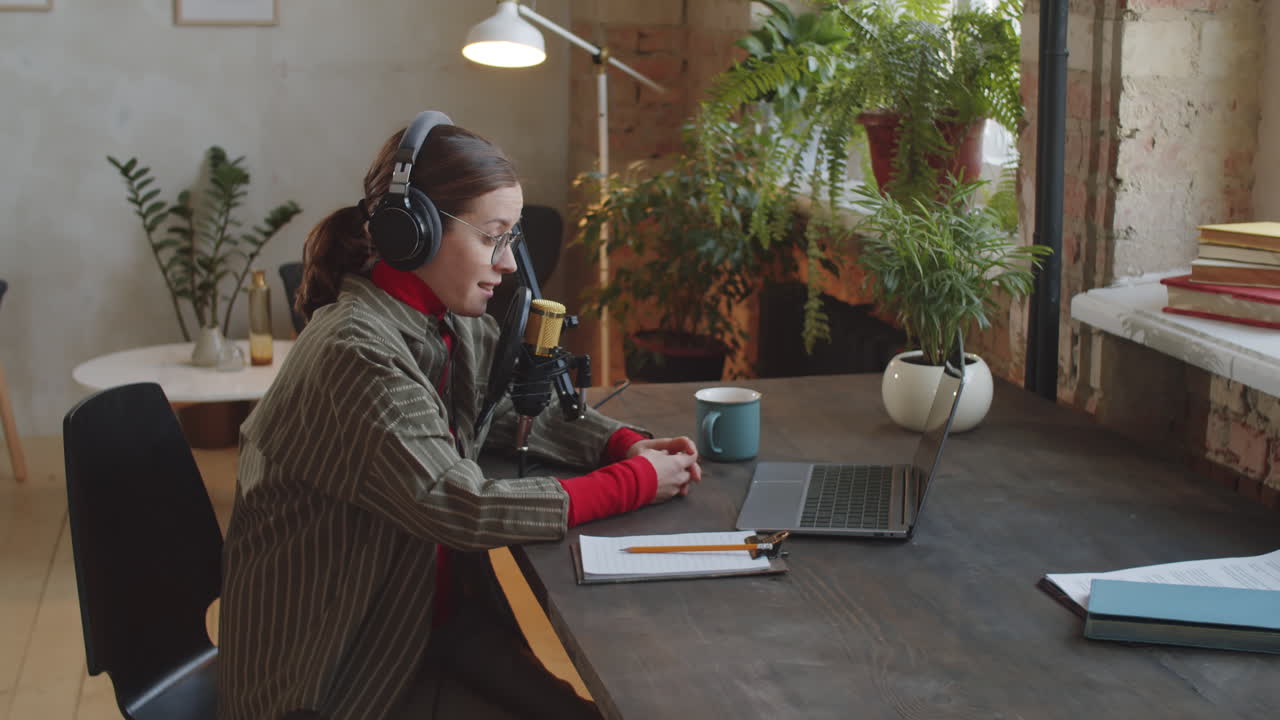 Kvindelig podcaster arbejder i et lydstudie