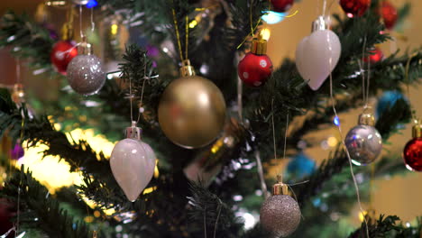 placing a white heart-shaped decoration on the christmas tree