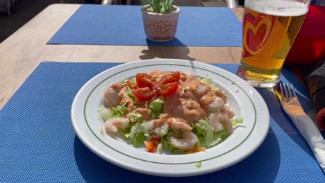 almuerzo en el café de la playa algarve portugal, ensalada de mariscos frescos y una pinta de cerveza local paradisíaca