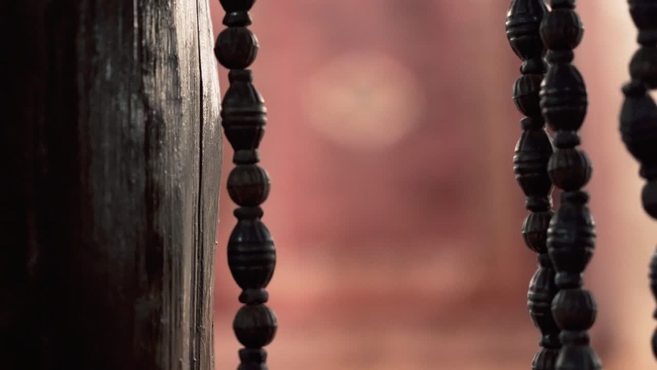 인도 아그라에 있는 호텔 레스토랑, 벽에 있는 카펫으로 나무 구슬 커튼 전환의 클로즈업 샷