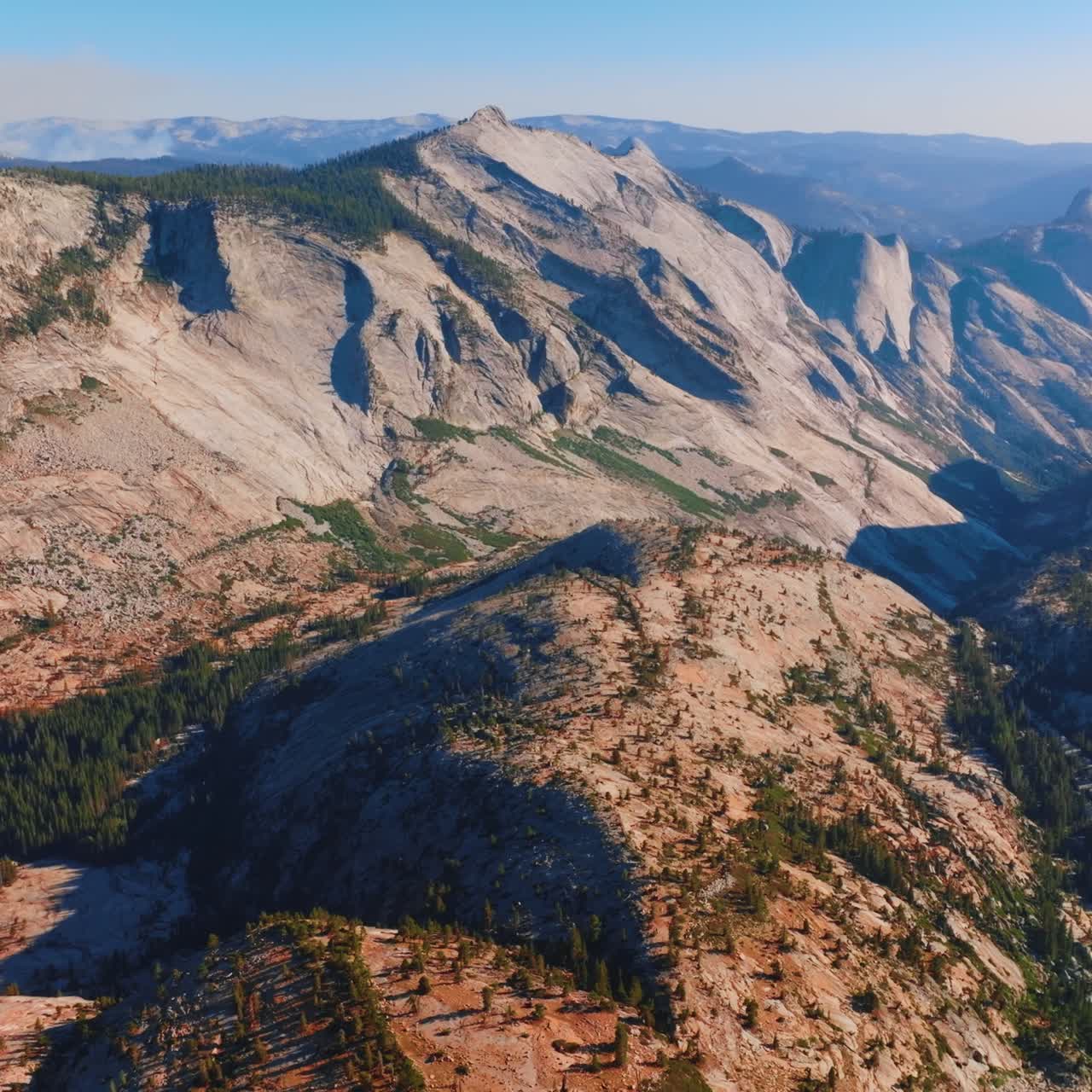 Grey rocks lit with bright sun. Mountainous landscape of Yosemite National Park, California, USA from bird's eye perspective