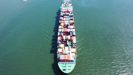 an aerial shot of a cargo ship with colorful containers on-board