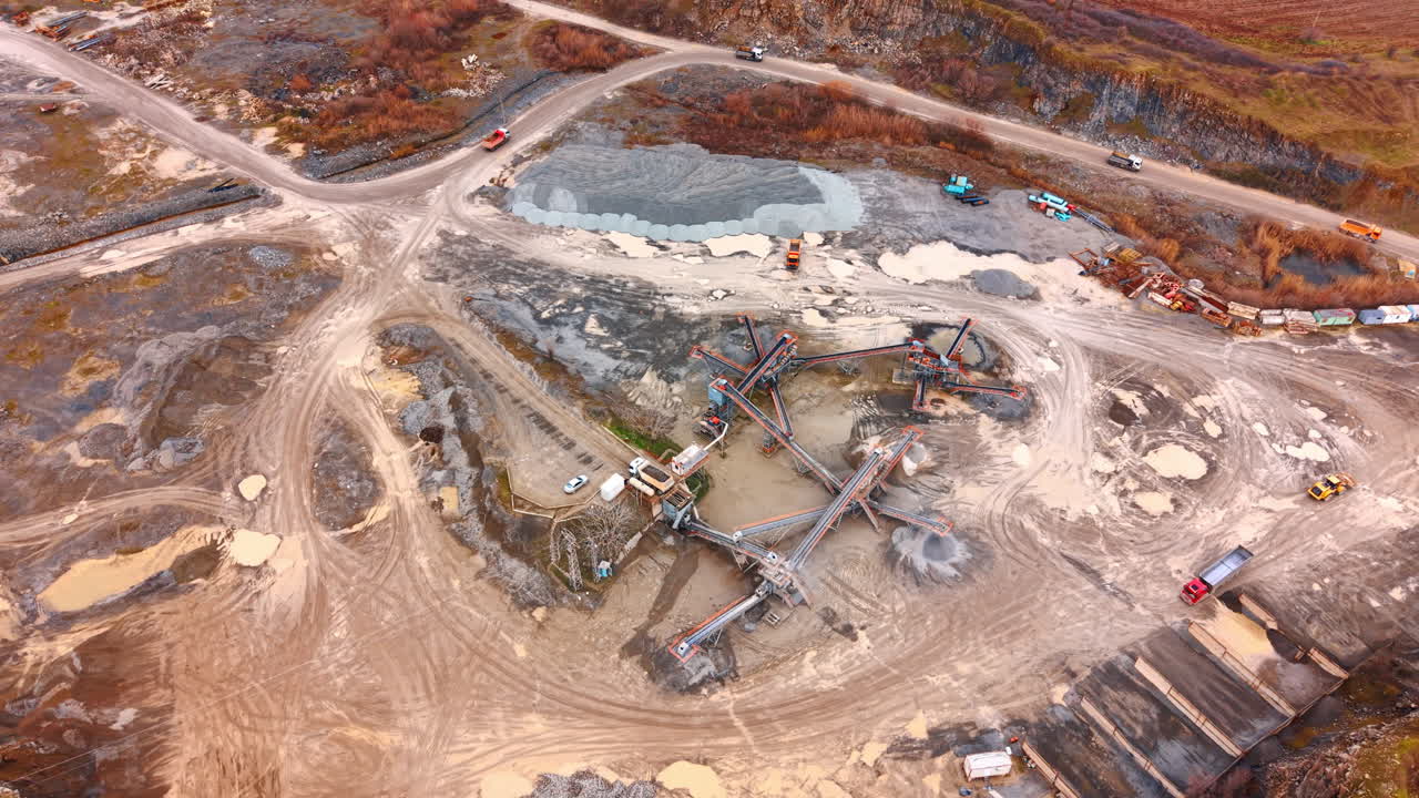 Machinery at work on site. Heavy machines and trucks are working at a construction site. Dust and materials are visible on the ground and around