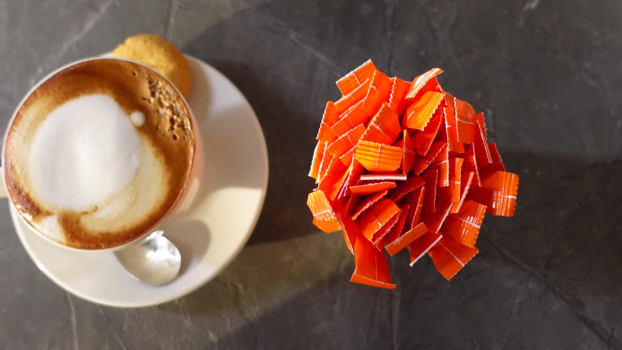 Top View of Cappuccino with Sugar Packets and a Cookie