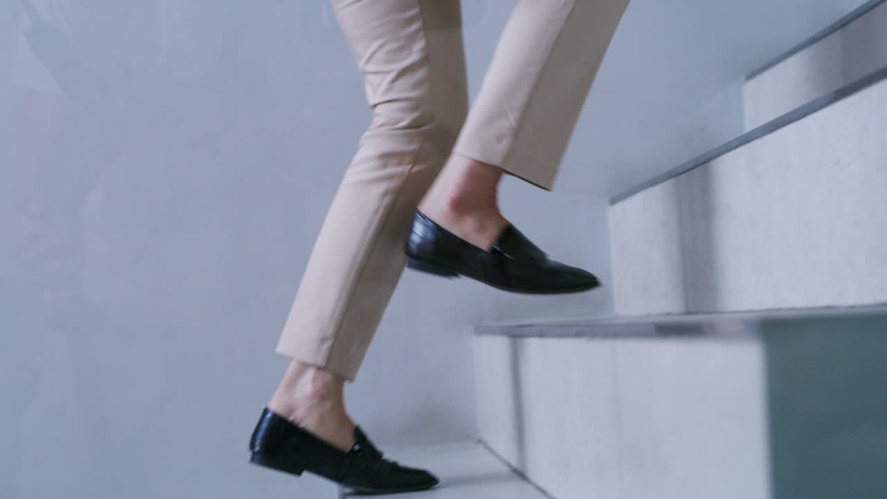 Person walking up stairs in dress shoes