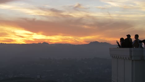 tourists watching sunset at griffith observatory