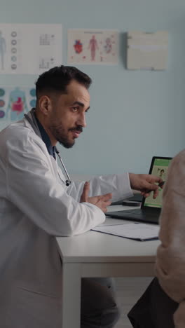 doctor explaining medical information to patient on laptop
