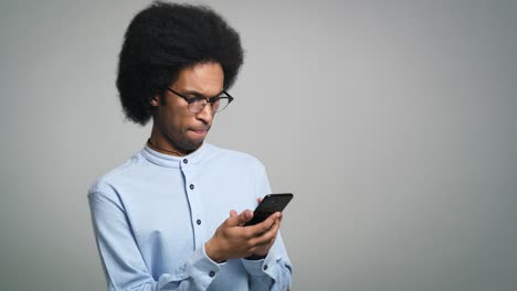 Un-Joven-Profesional-Independiente-Africano-Utiliza-Un-Teléfono-Digital-En-Una-Foto-De-Estudio.