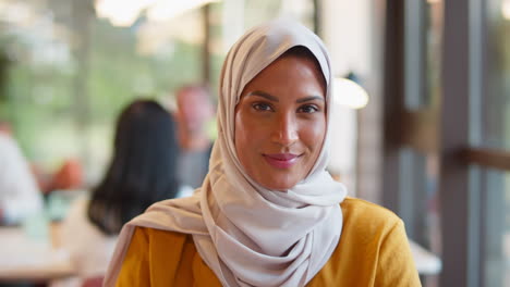portrait of mature businesswoman wearing headscarf working at desk in office