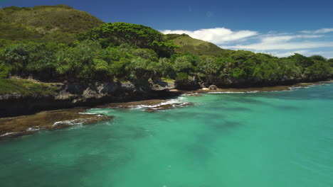 Gradual-aerial-arc-of-waves-breaking-against-rocky-coast-on-Isle-of-Pines