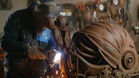 welding rusty metal sculpture in a workshop