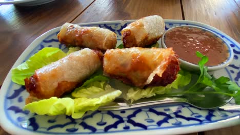 Traditional-spring-rolls-on-lettuce-with-sweet-chili-sauce-in-a-Thai-restaurant,-tasty-asian-food,-4K-shot