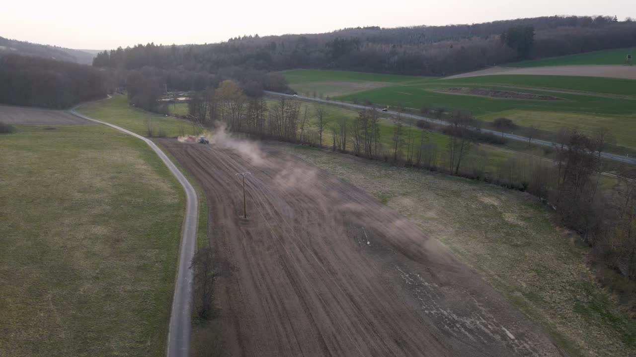 Un campo marrone polveroso preparato dal trattore di un agricoltore durante un tramonto in Germania