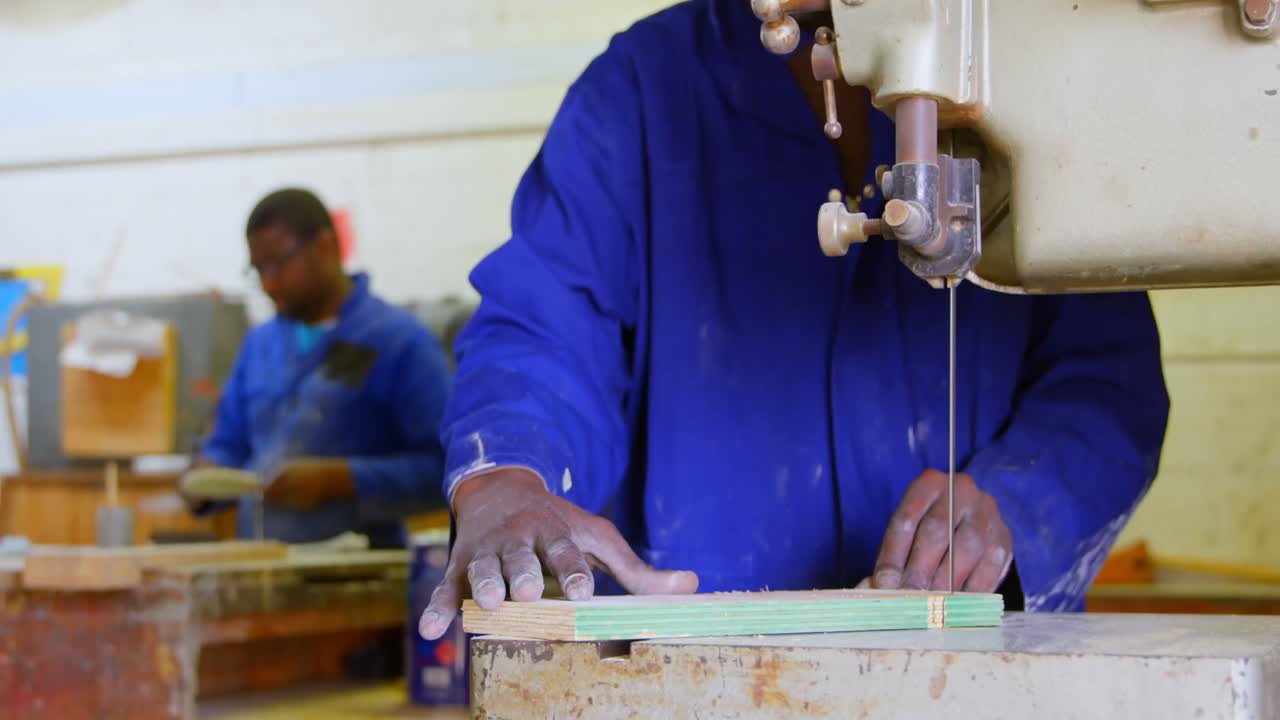 Worker cutting pine board at band saw in workshop 4k