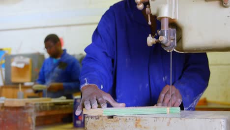 worker cutting pine board at band saw in workshop 4k