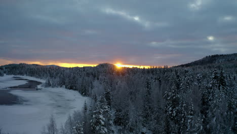 aerial view across scenic golden sunrise over frozen lapland woodland mountains