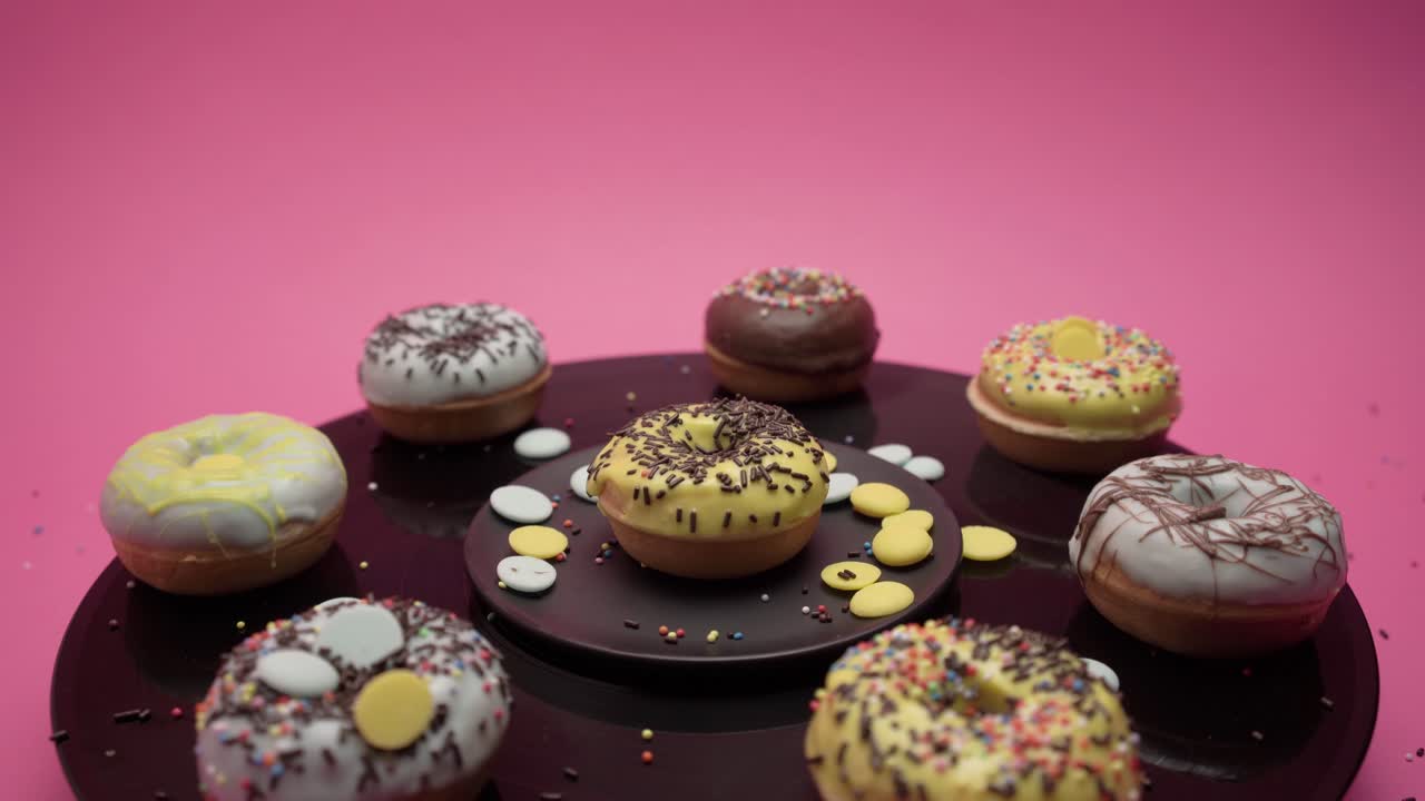 Eight American donuts spin on a black music board