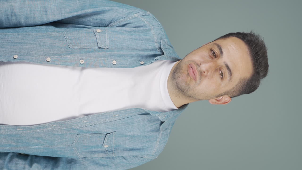 vídeo vertical del hombre que suspira y sopla por aburrimiento.