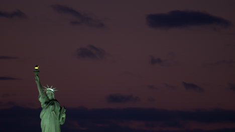 statue of liberty framed far left with sky nearly dark