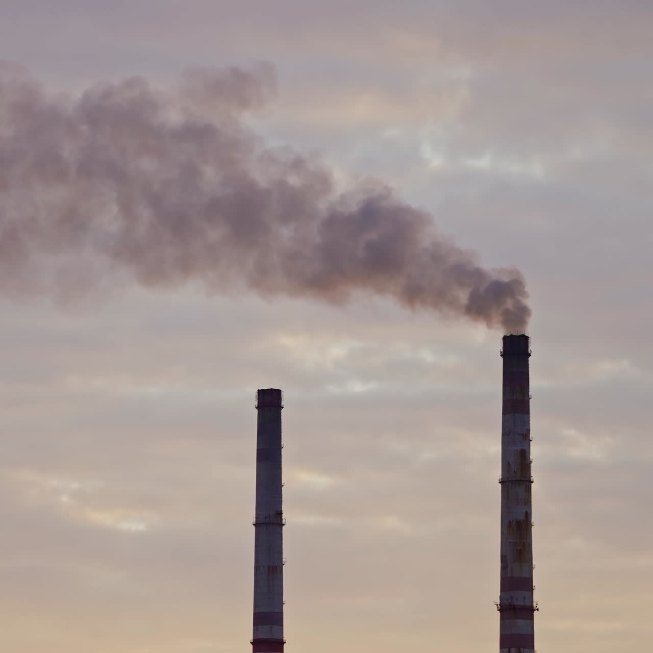 Factory chimneys with smoke. Beautiful sunset over river. View from the top